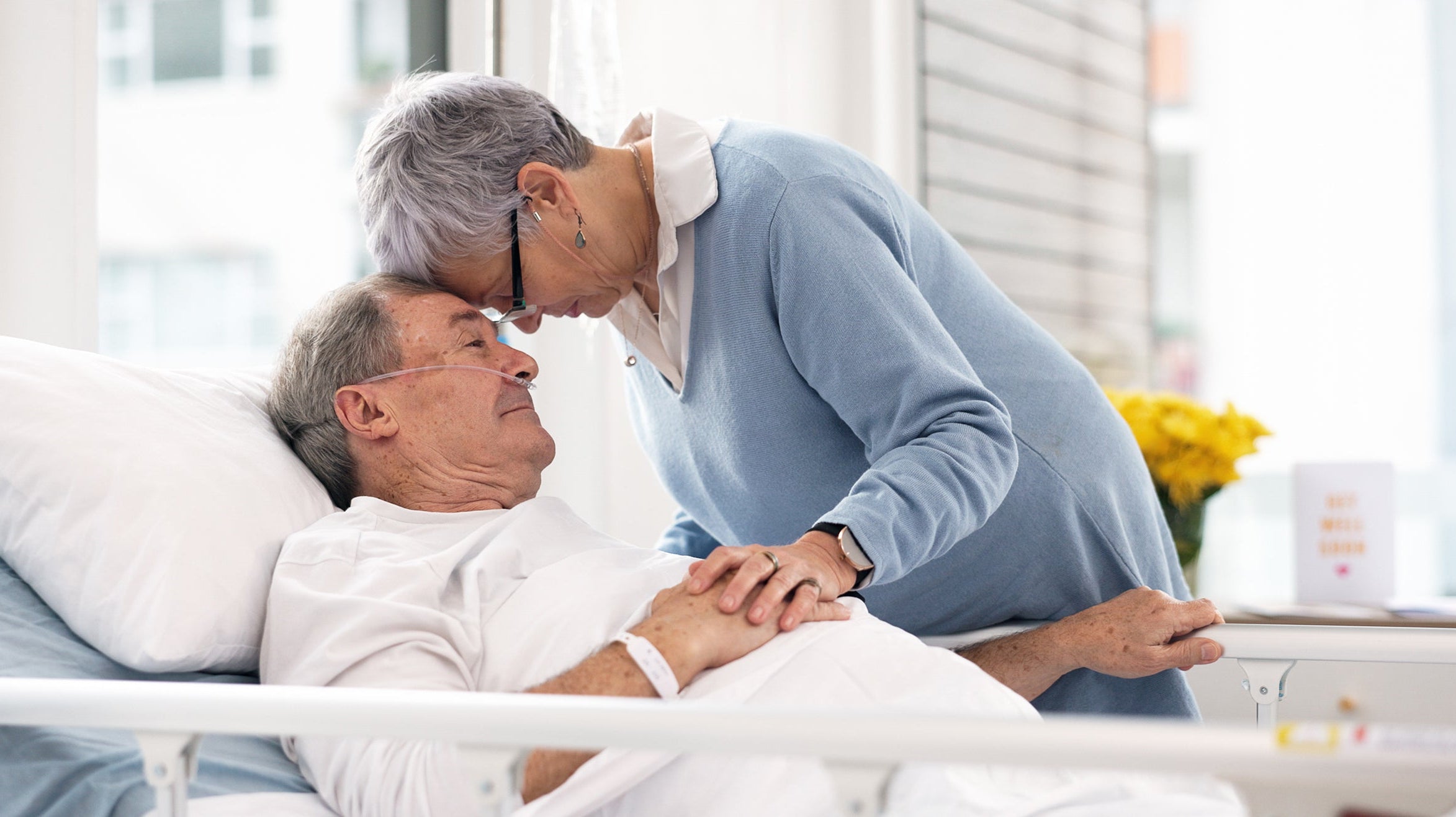 A woman comforts a man in a hospital bed. Cancer pain is complex — but manageable. Learn how medication, therapy, and sleep positioning support comfort and quality of life during treatment.