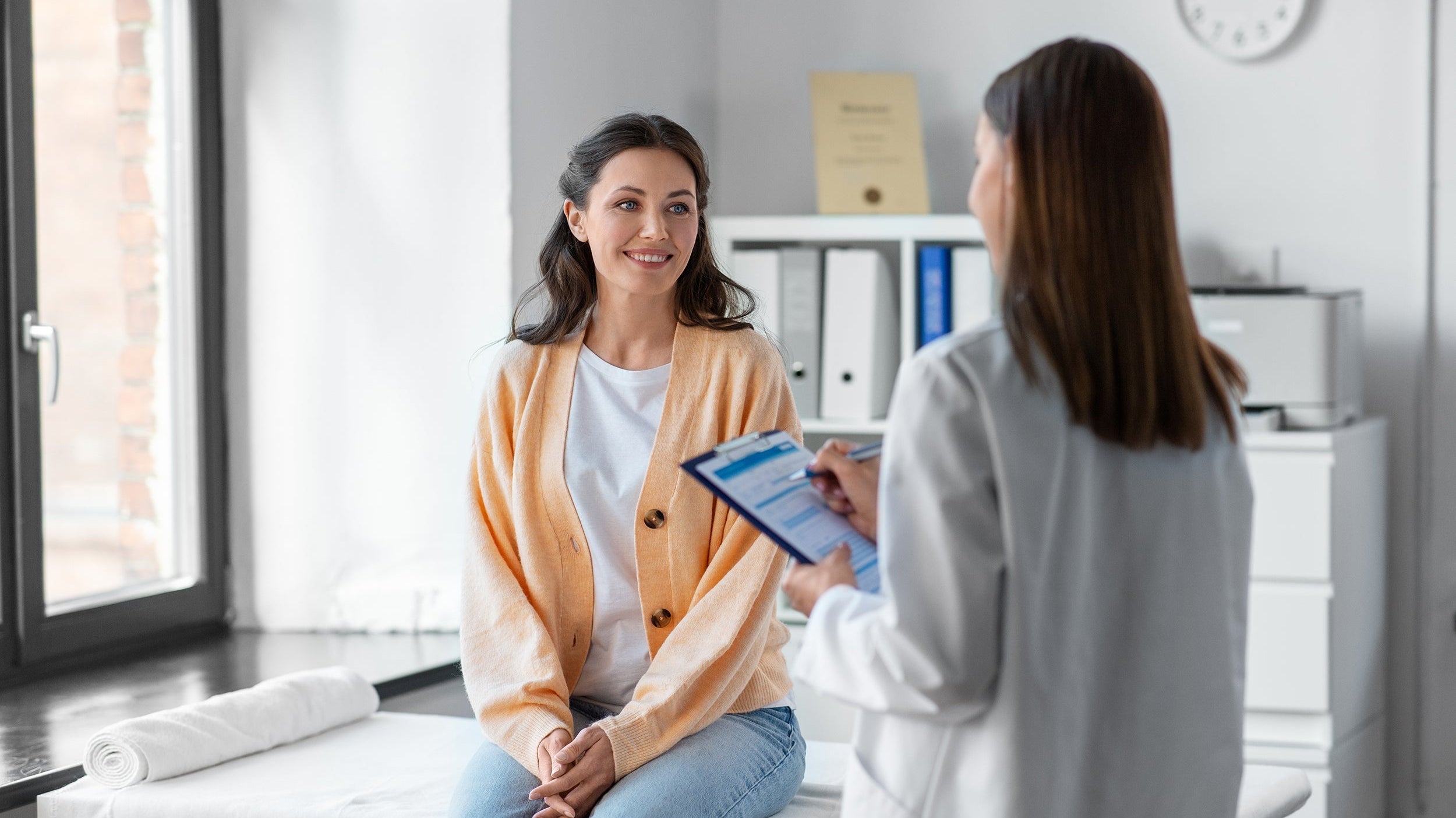 A woman consults with a doctor. If you're preparing for a breast augmentation, knowing how long you have to sleep elevated is important. Learn more in our guide.