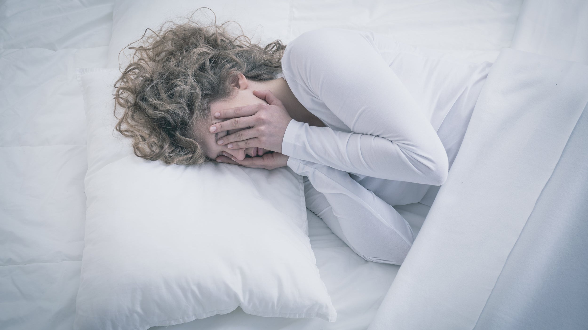 A woman struggles to sleep. Learn how to sleep after BBL surgery using elevated positioning that protects transferred fat cells. Complete guide to BBL recovery sleep positions and equipment.