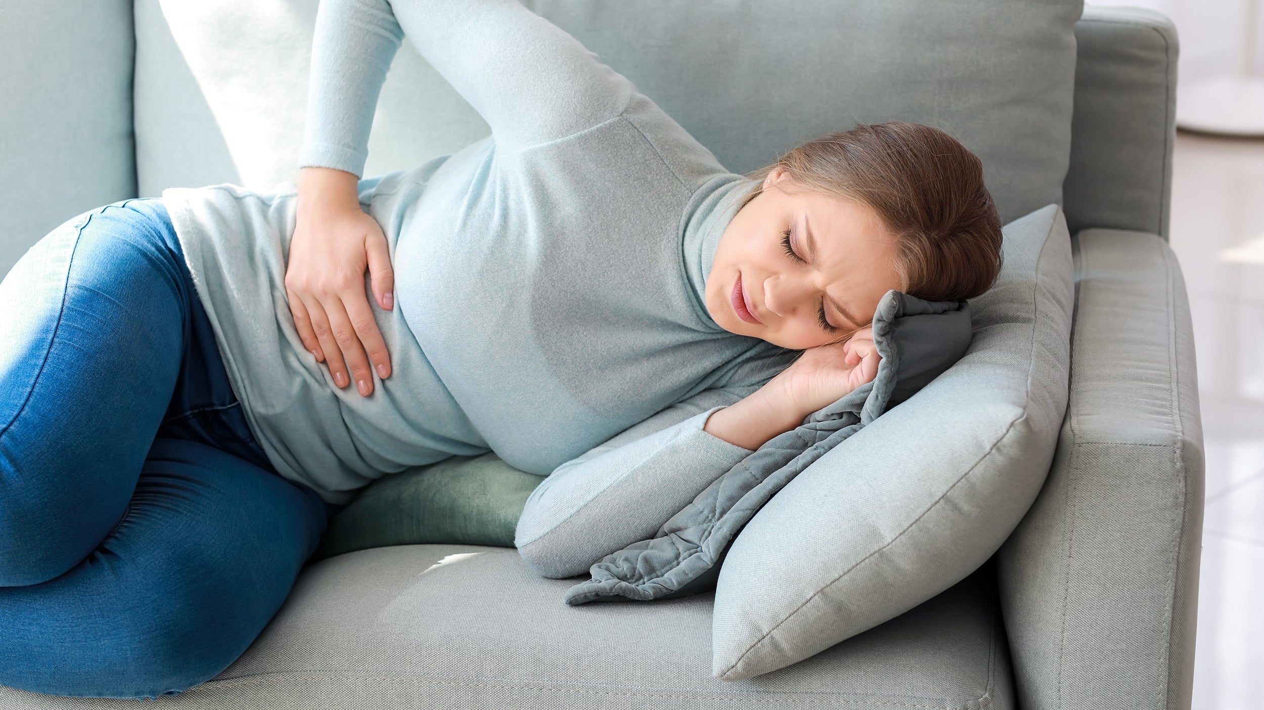 A woman with side pain. How to sleep after an appendectomy: the best positions, what to avoid, week-by-week recovery timeline, and the sleep setup worth having ready before surgery.