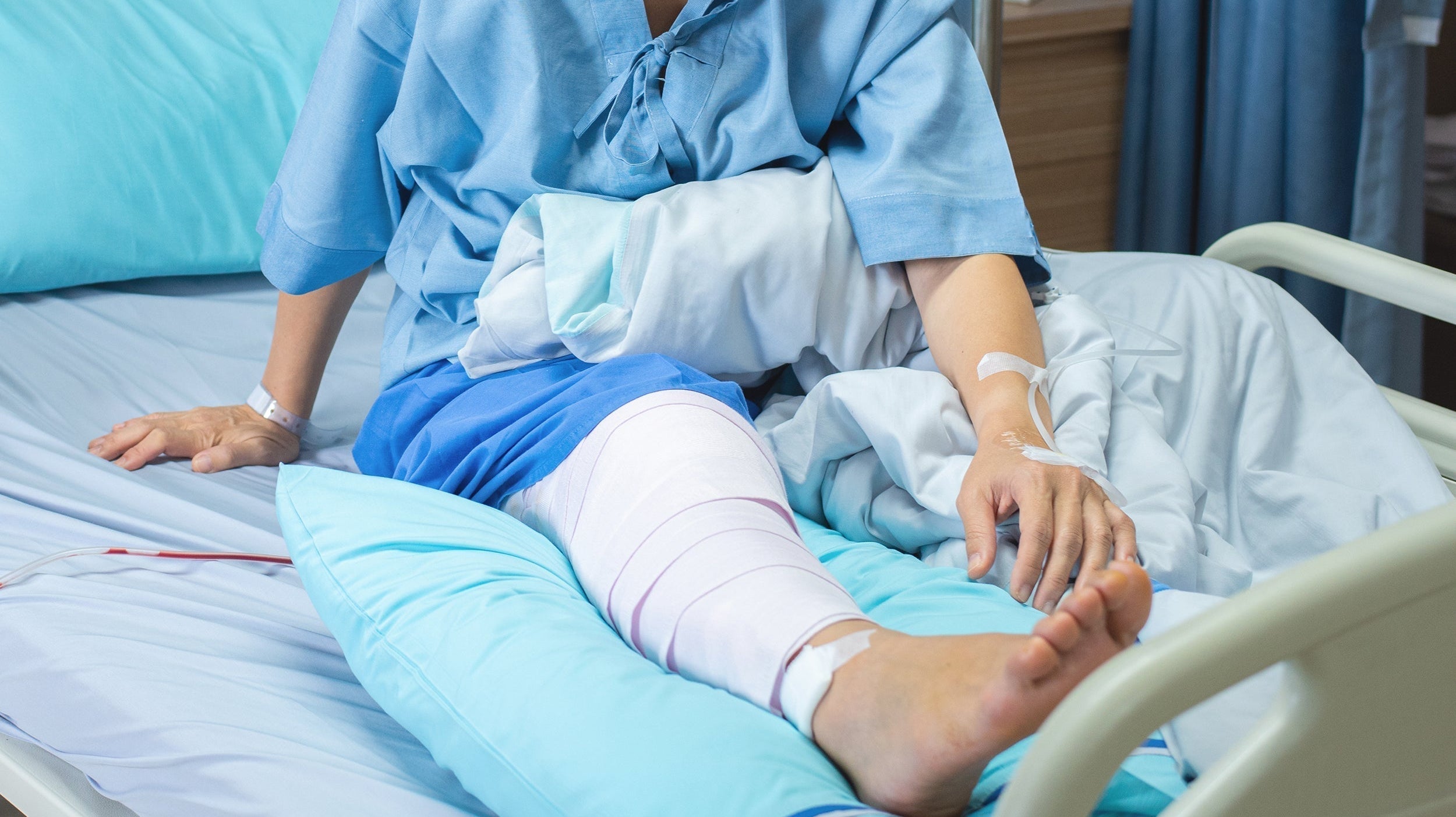 A woman recovers in a hospital bed after ACL surgery. Sleeping after ACL surgery can be challenging. To boost healing and recovery, explore our guide on how to sleep after ACL surgery.