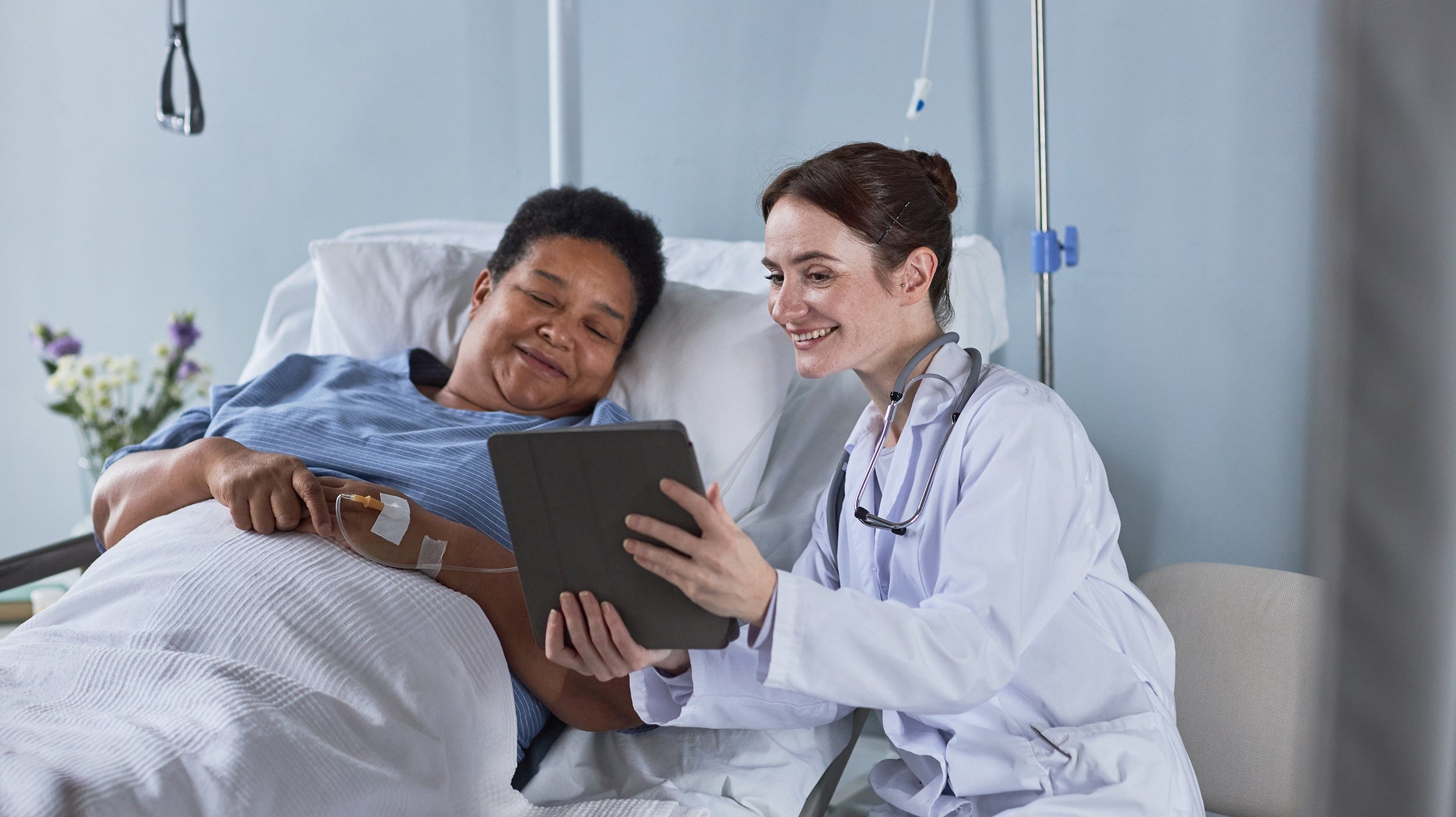 A doctor talks to a woman in a hospital bed. If you're preparing for gastric sleeve surgery, be sure to check out our essential healing guide on how to sleep after gastric sleeve surgery and get the rest you deserve.