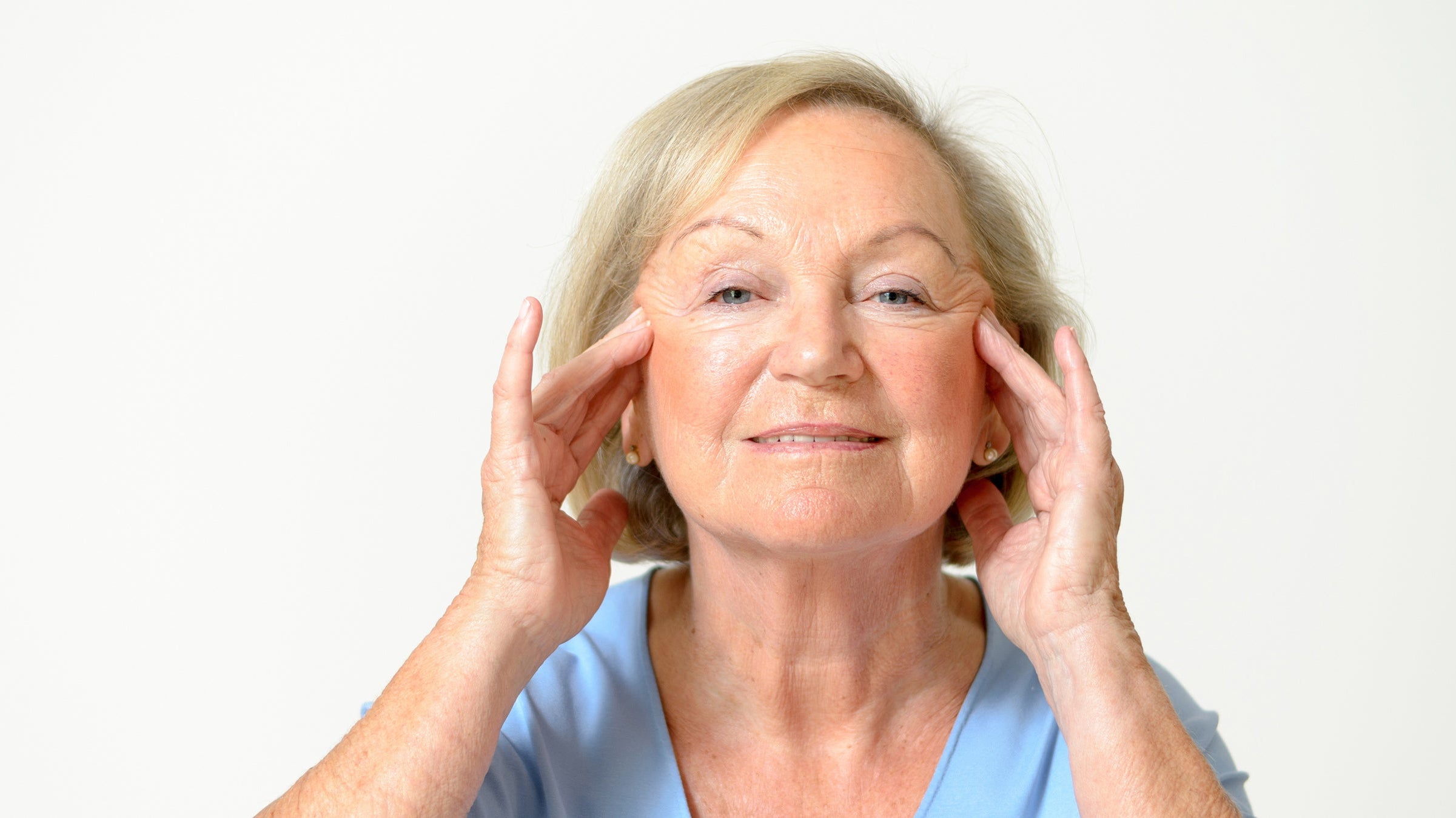 A woman looking at her own face. Planning a facelift? Explore the best facelift recovery must-haves and be prepared well before surgery day.