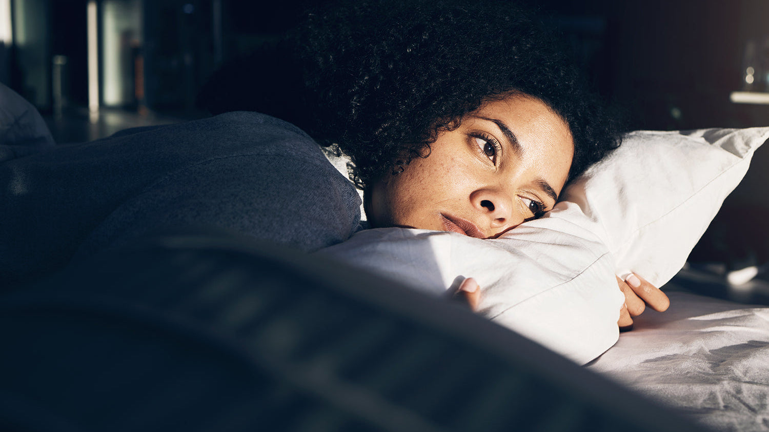 A woman struggling to sleep. Standard back sleeping isn't safe after butt implant surgery, but stomach sleeping isn't your only option. See how suspension-based positioning changes that.