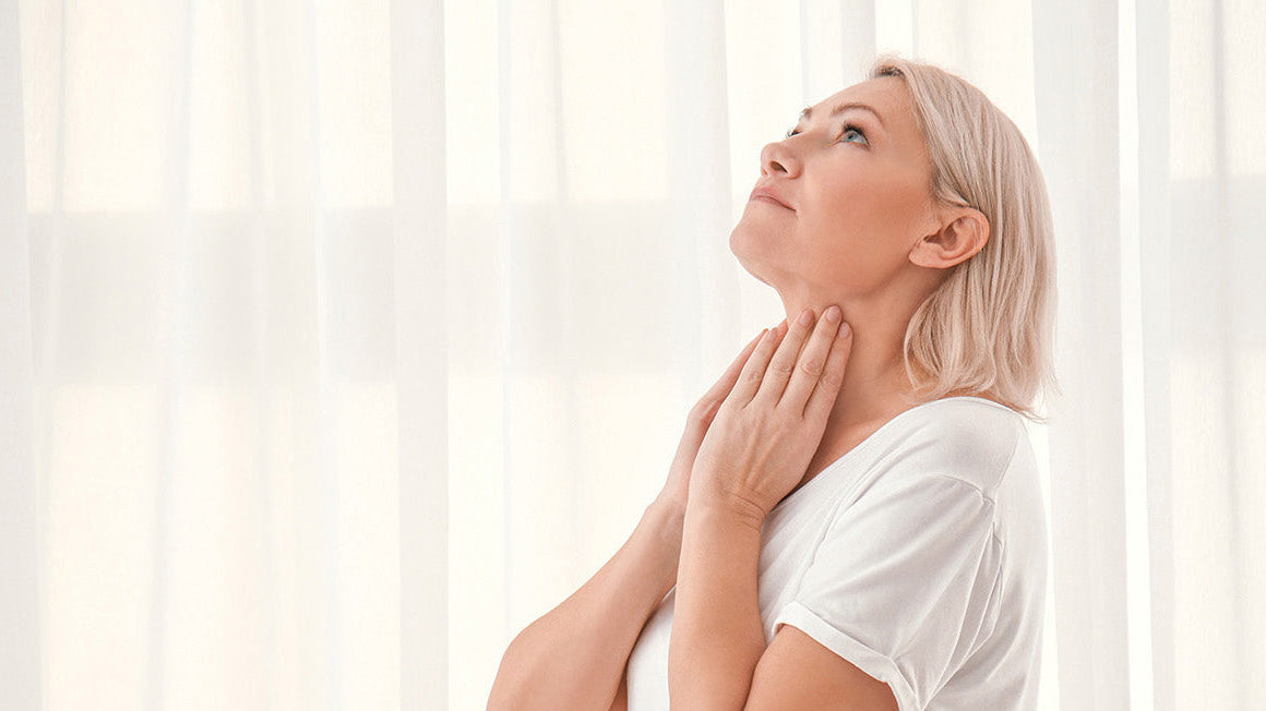 A woman touching her neck. Thyroid surgery affects how you sleep — neck positioning, swelling, and incision pain all play a role. Learn safe sleep positions for recovery.