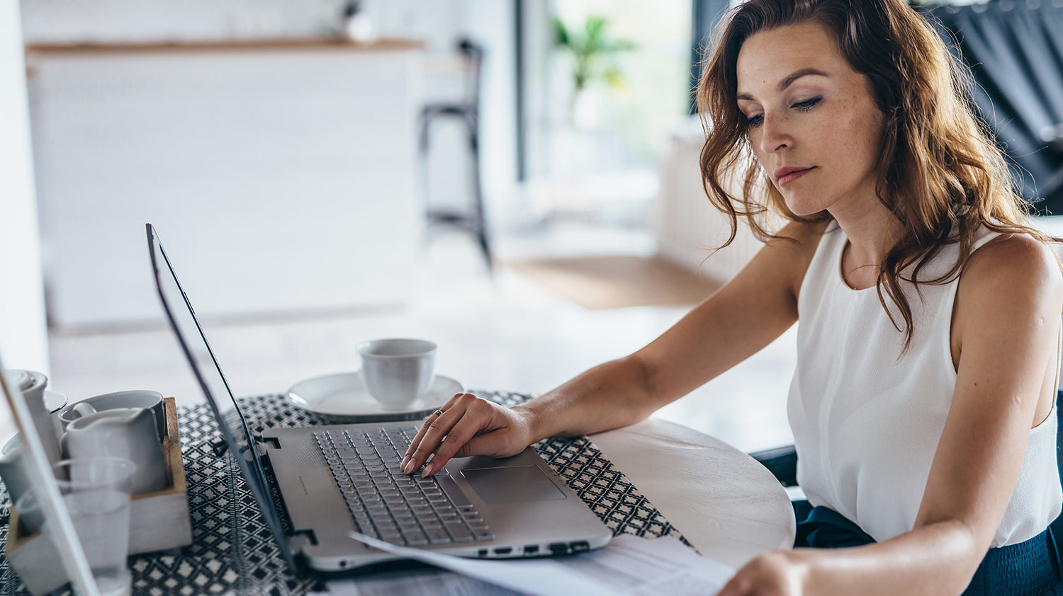 A woman creates a checklist using her computer. Looking for how to support your breast augmentation recovery? Check out our must-haves list for top healing essentials.