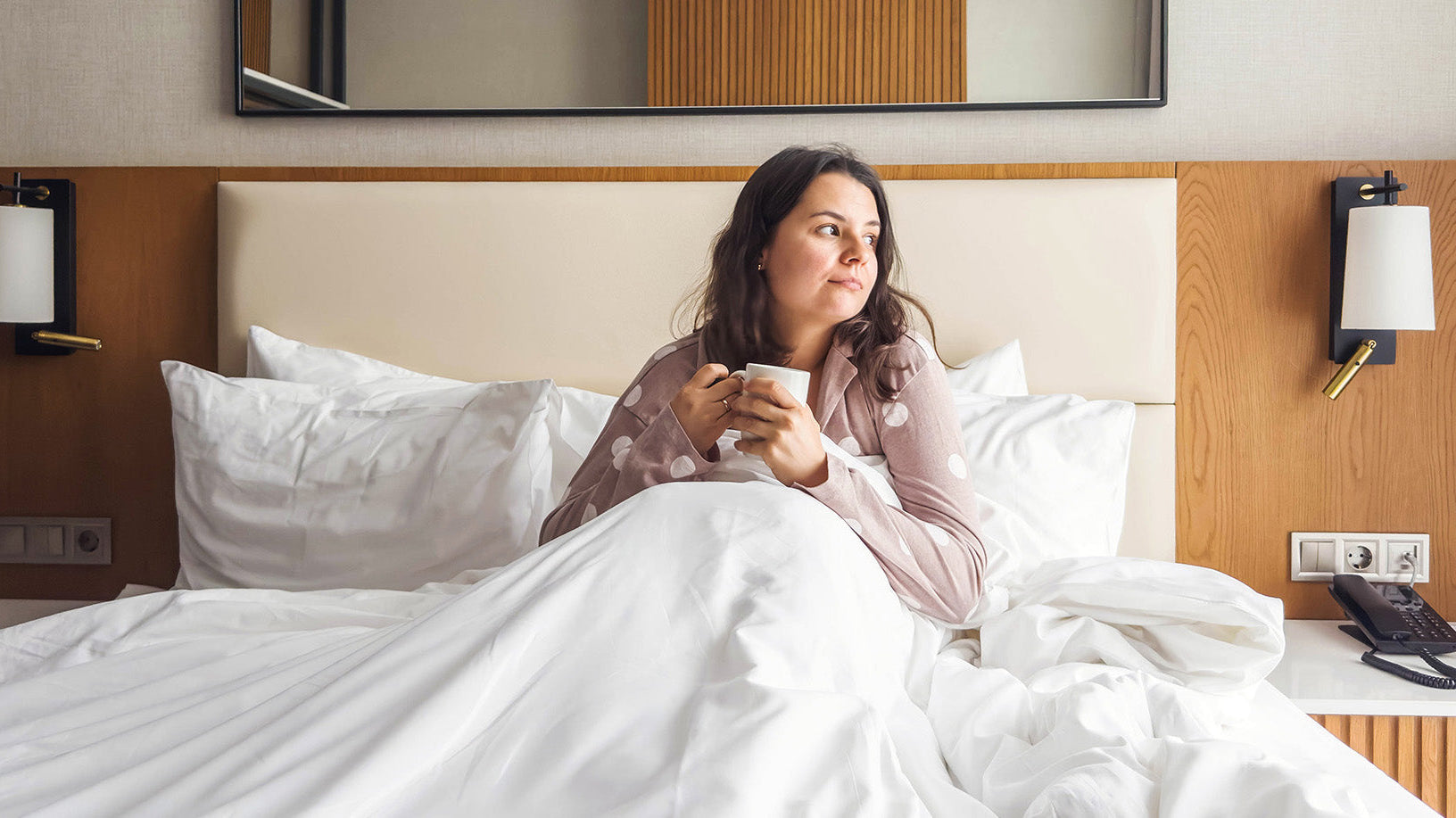 A woman sits up in bed. Getting a tummy tuck? Build your pre-op checklist now, from sleep positioning to compression garments, so recovery supplies are ready before your surgery day.