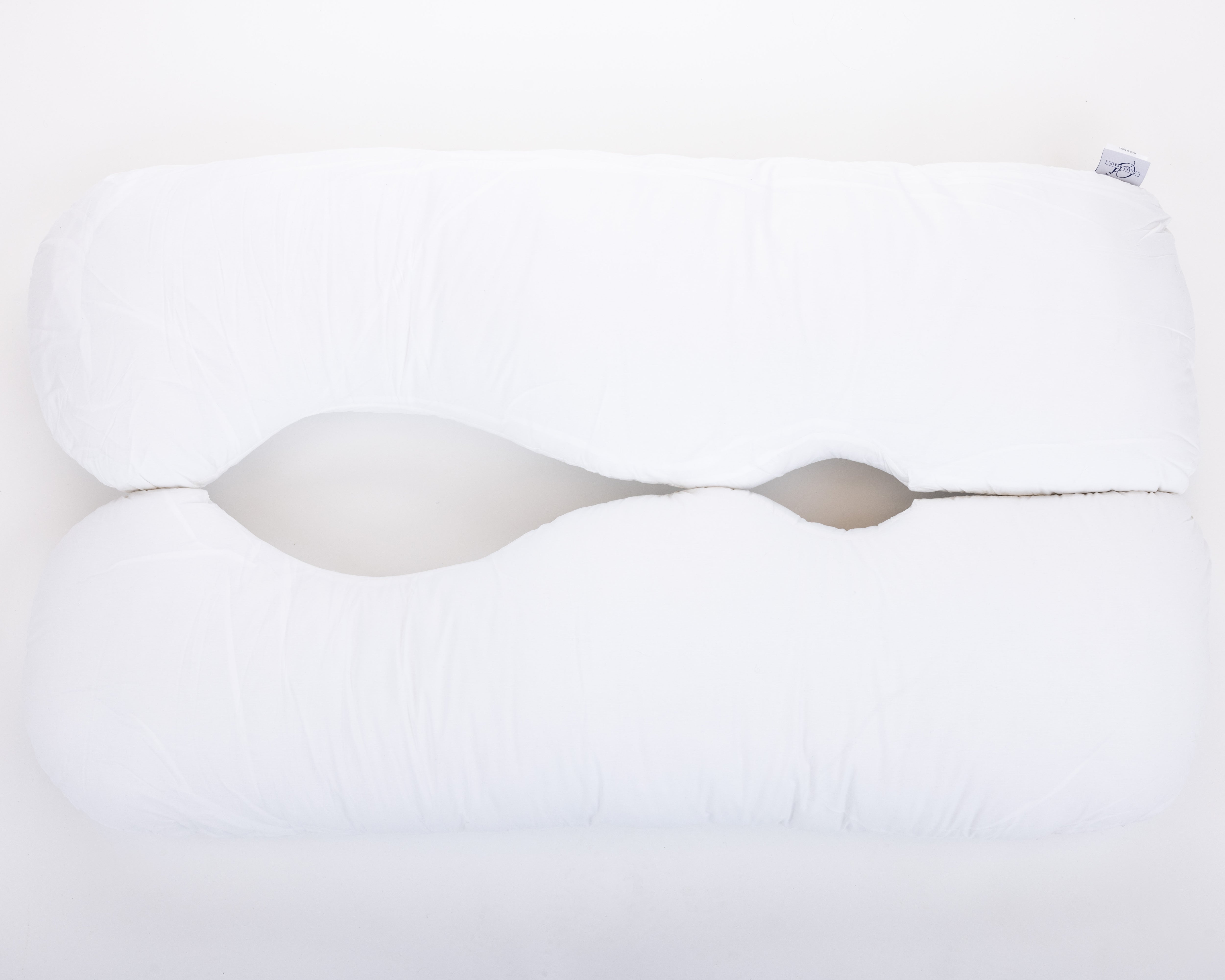 The "Two Side Pillows Sold Separately" is a white, uniquely contoured bedding pillow with a wave-like center cutout, shown on a plain white background.