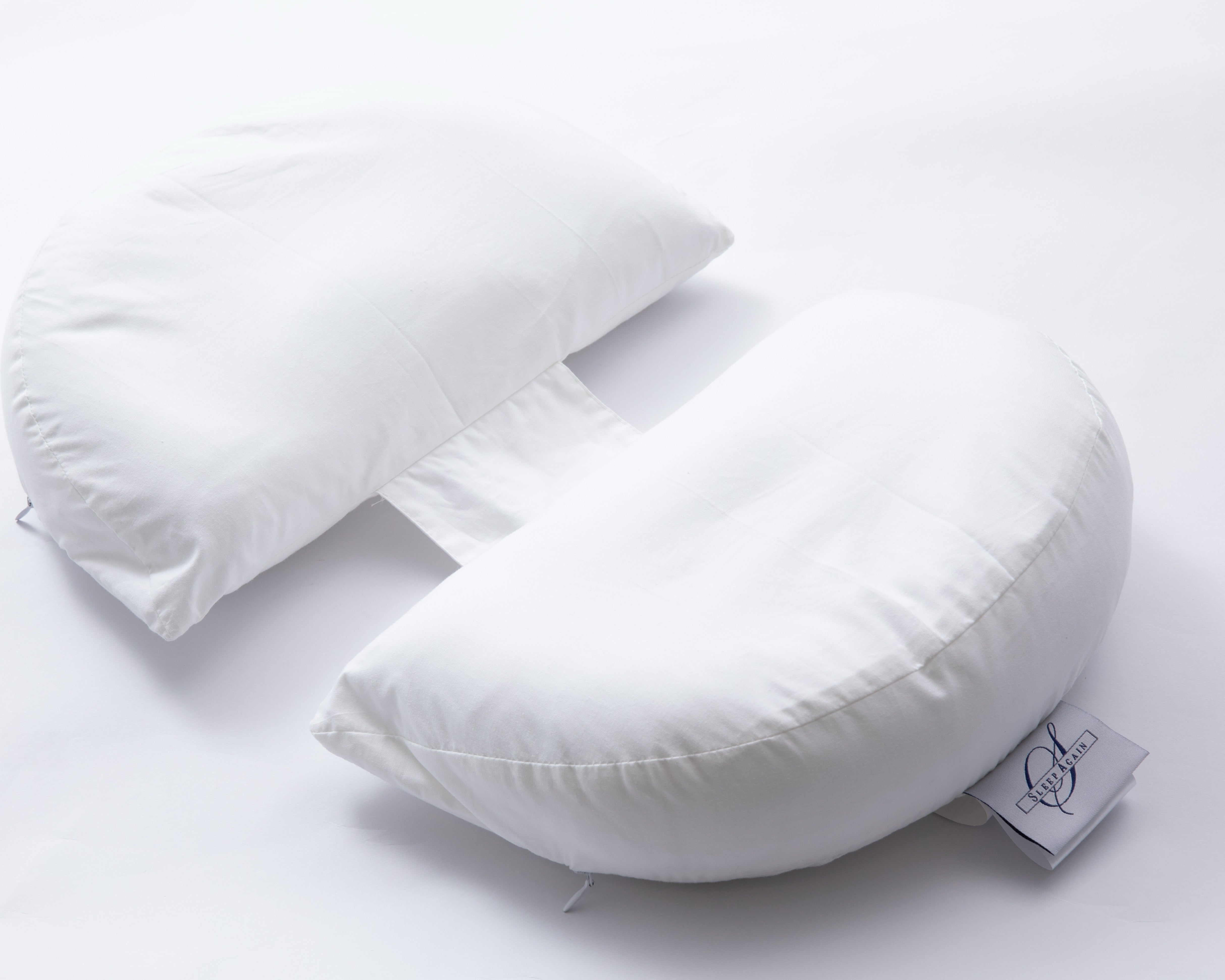 The Side Sleeping Chest Pillow, a butterfly-shaped white pillow with a curved center gap and fabric strip, is shown on a white background. A logo tag accents one side, making it ideal for post-surgery breast support.