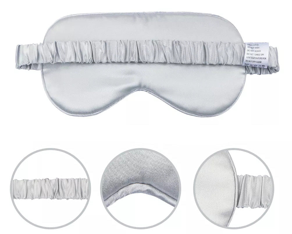 The Mulberry Silk Sleep Eye Mask with Silk Covered Elastic Strap is pictured in silver. Three circular insets show the strap, soft inner lining, and mask edge. A fabric care label is attached to this luxurious blackout mask’s strap.