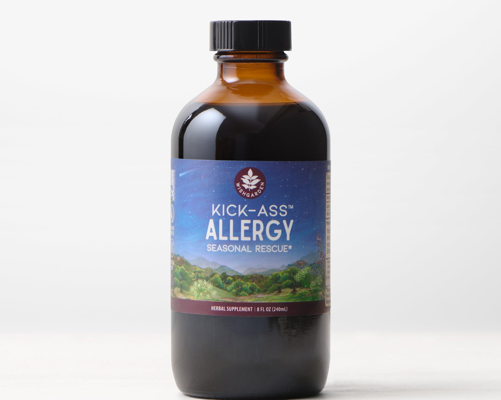 A bottle of Kick-Ass Allergy, Seasonal Rescue liquid herbal tincture with a scenic label rests on a light surface against a white background—ideal for natural allergy relief.