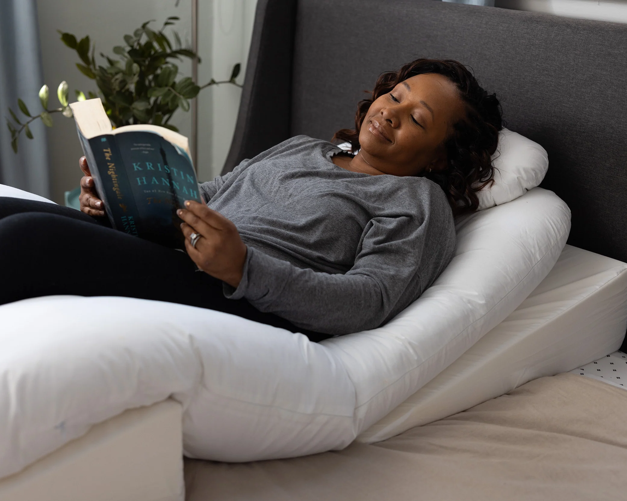 A woman rests on her back using the Sleep Again Pillow System, a BBL pillow designed for back sleeping following a Brazilian butt lift.