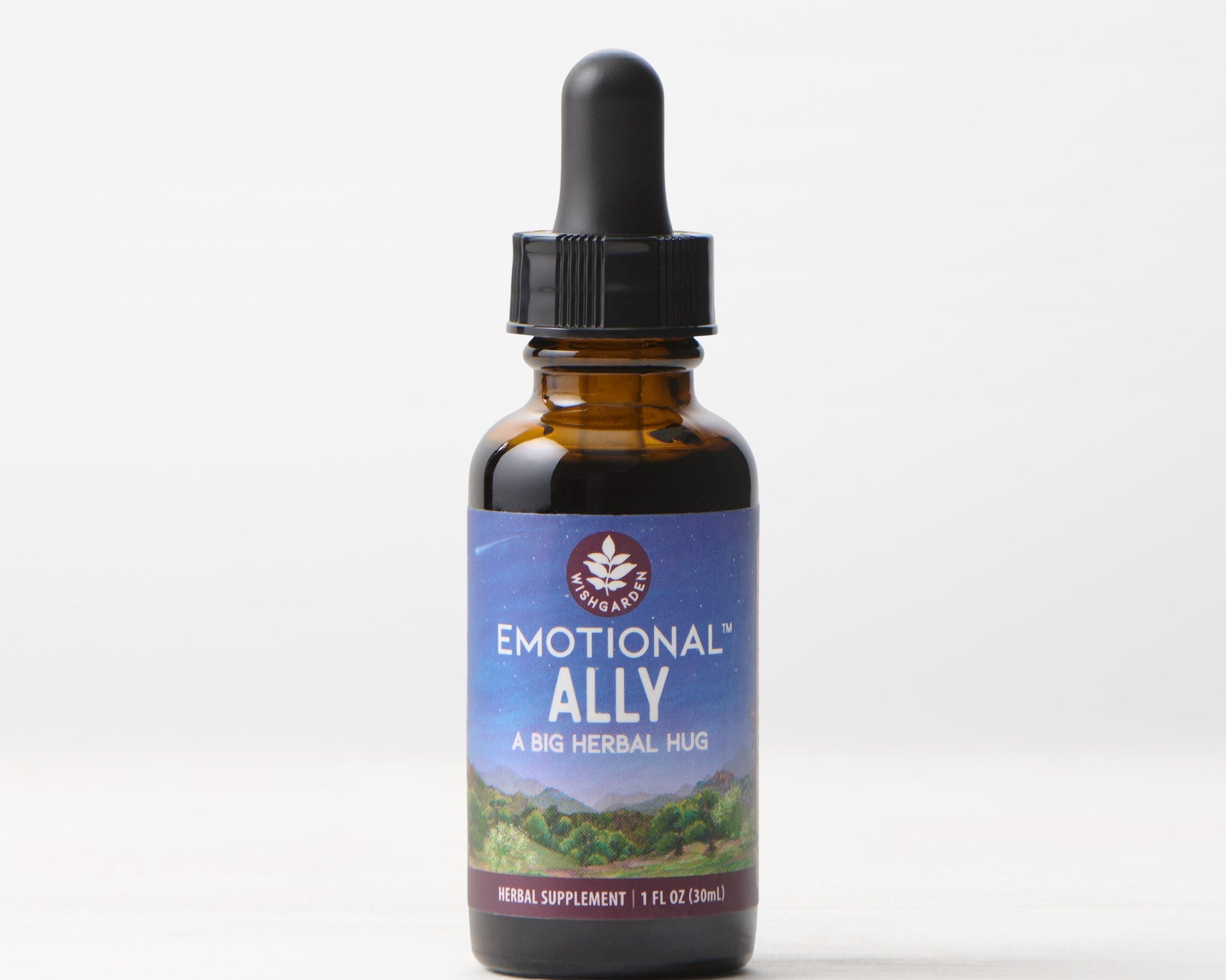 A brown glass dropper bottle labeled Emotional Ally: A Big Herbal Hug rests on a light surface with a simple background. The label, showing a nature scene, identifies this 1 fl oz herbal supplement as a blend for mood and emotional support.