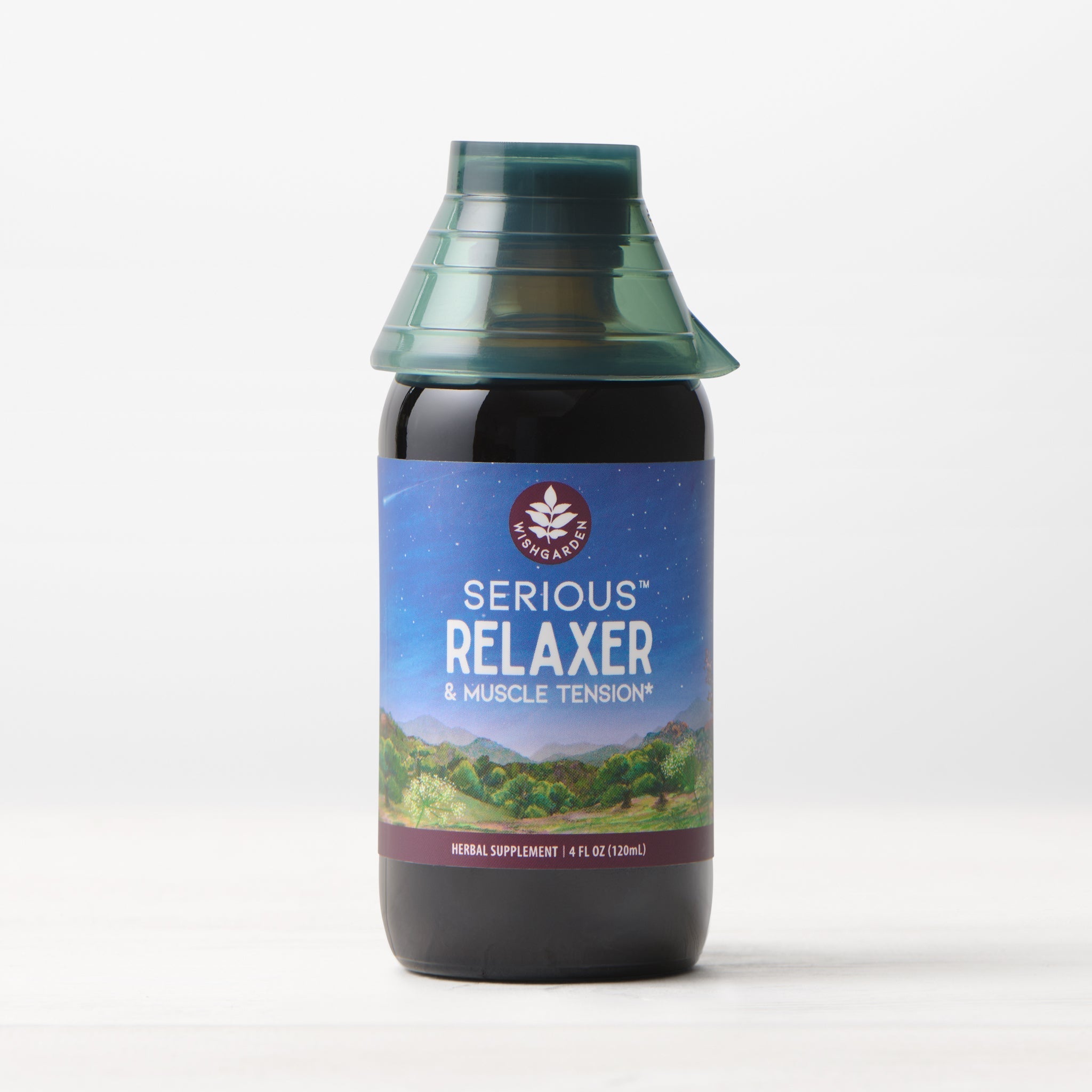 A bottle of Serious Relaxer & Muscle Tension herbal supplement with a green cap sits against a light background; its label displays a peaceful mountain and starry night scene, emphasizing sleep aid and muscle tension relief benefits.