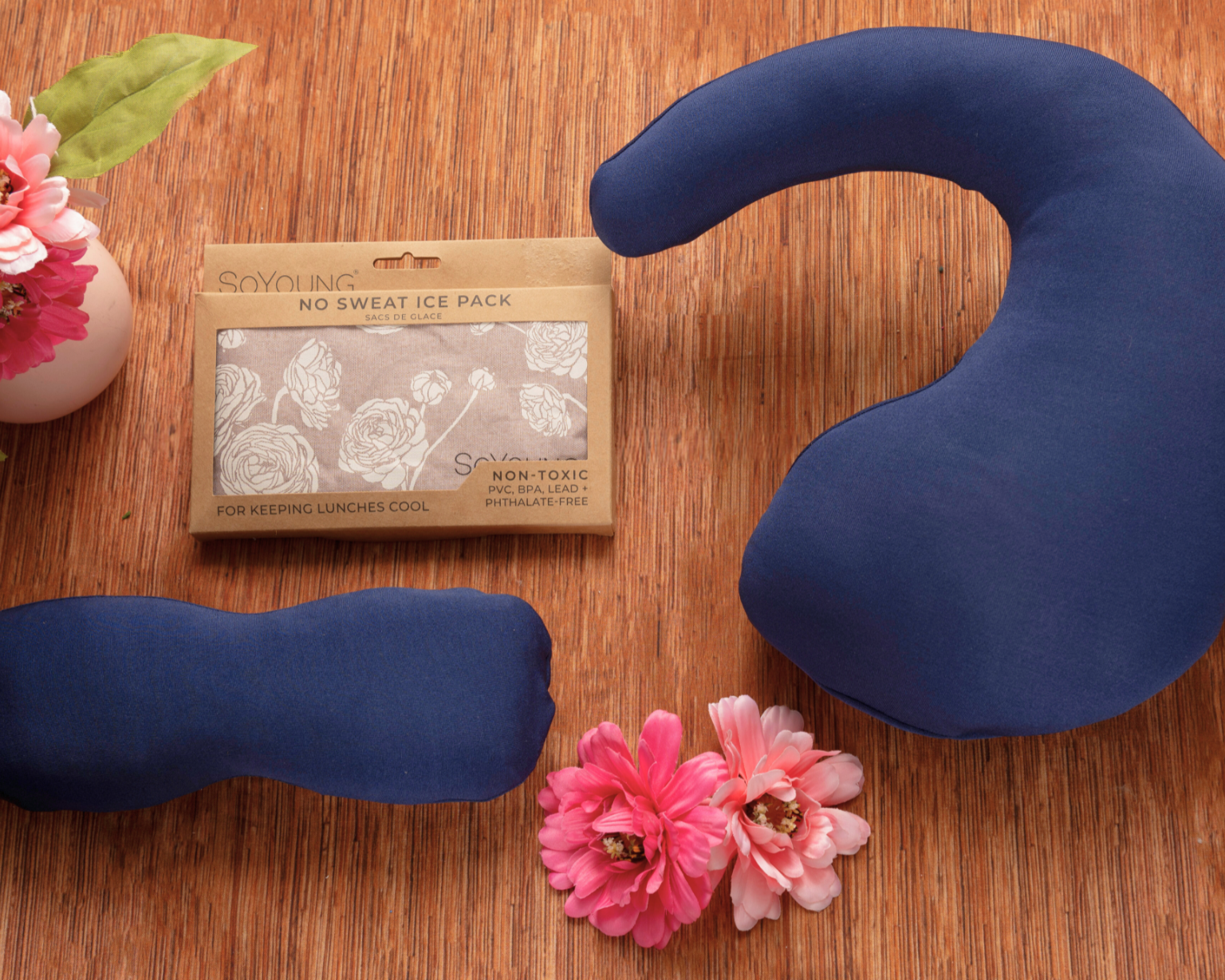 Three blue fabric ice packs in assorted shapes are shown with pink flowers and a "No Sweat Ice Pack" package—perfect for including in The Best Mastectomy Care Package or as part of a breast cancer gift box.