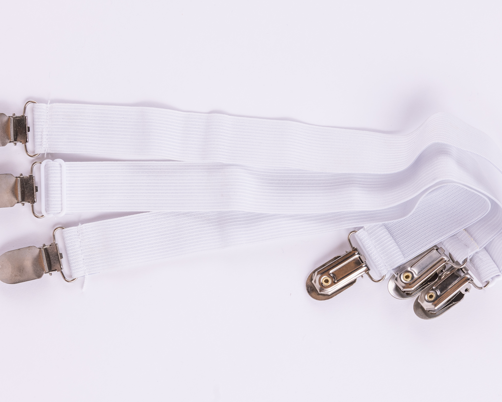 Three white elastic bed sheet straps with metal clips, side by side on a plain white background—perfect for securing your Sleep Again Pillow System or holding contoured side pillows in place.