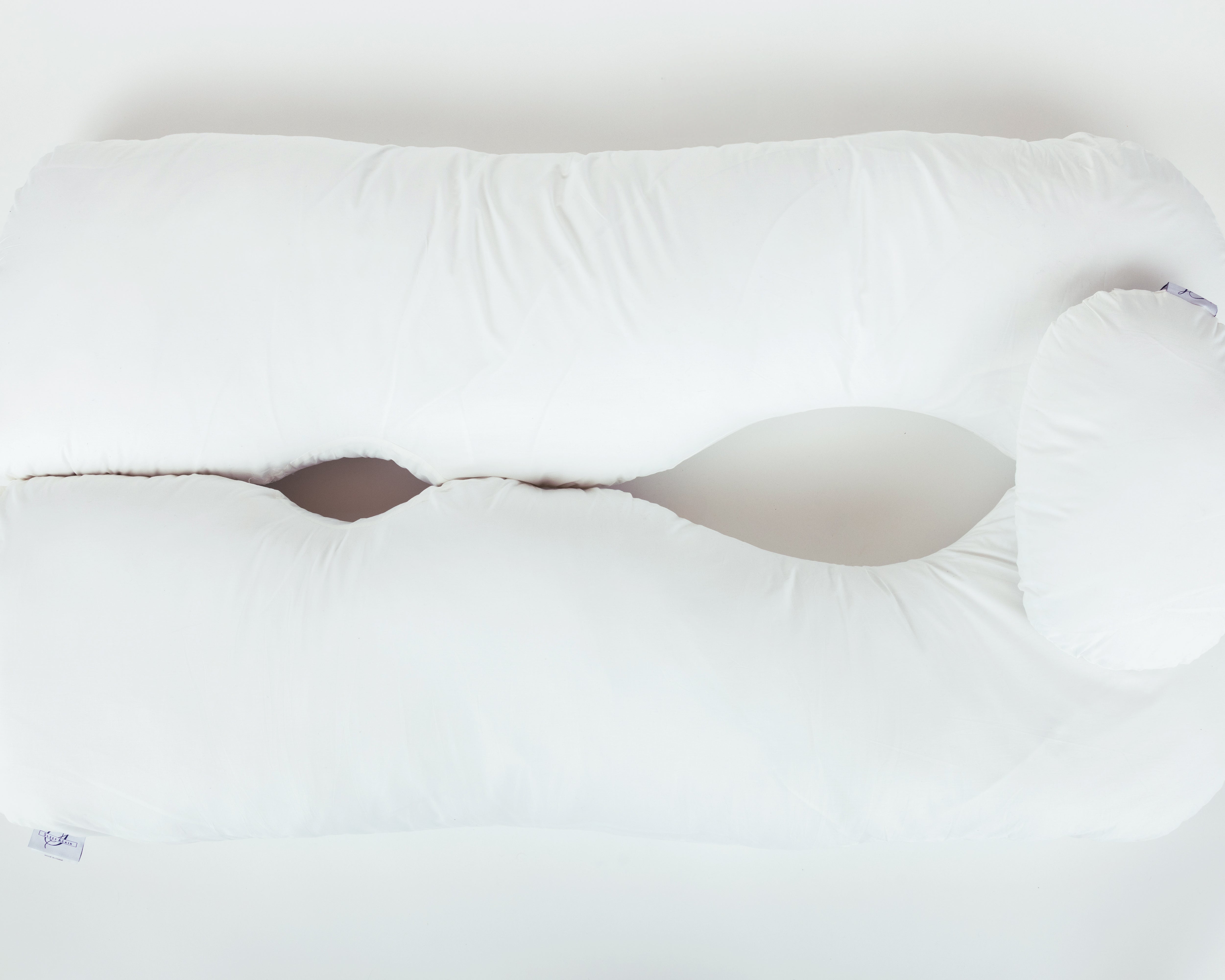 A large, white, U-shaped body pillow with a curved design and open center, featuring a washable slipcover (Two Side Pillows Sold Separately), placed on a plain white background.
