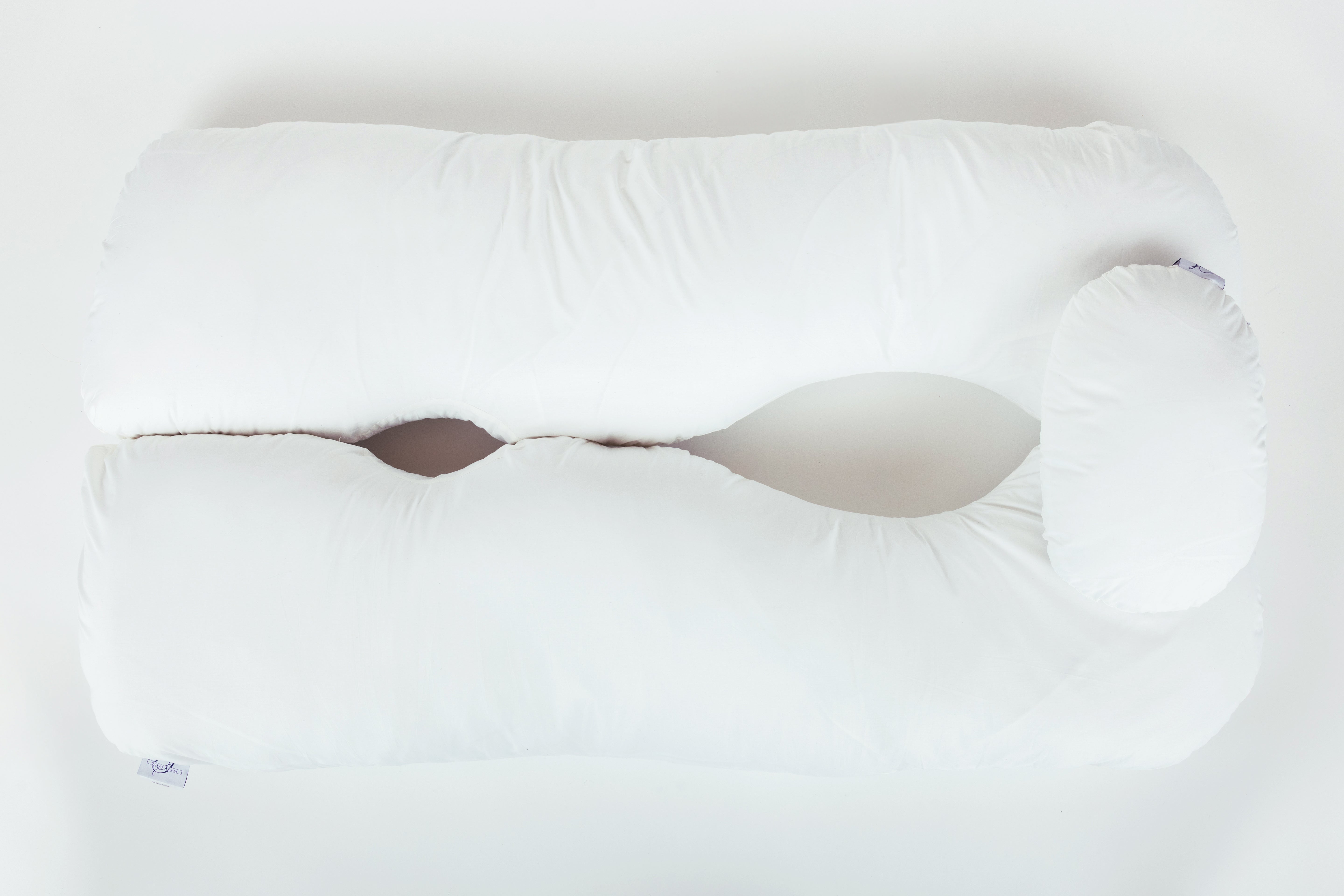 A large, white, U-shaped body pillow with a curved design and open center, featuring a washable slipcover (Two Side Pillows Sold Separately), placed on a plain white background.