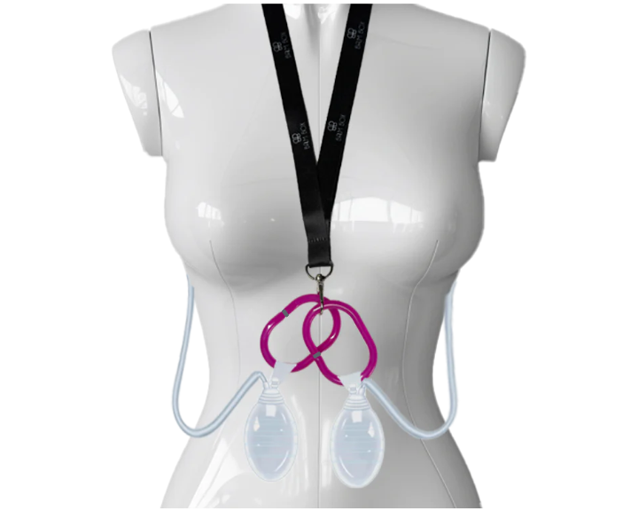 A mannequin torso displays the Surgical Drain Holder with two clear drains and tubing, attached to a neck lanyard and pink clip, used for collecting post-surgical fluid after breast surgery.