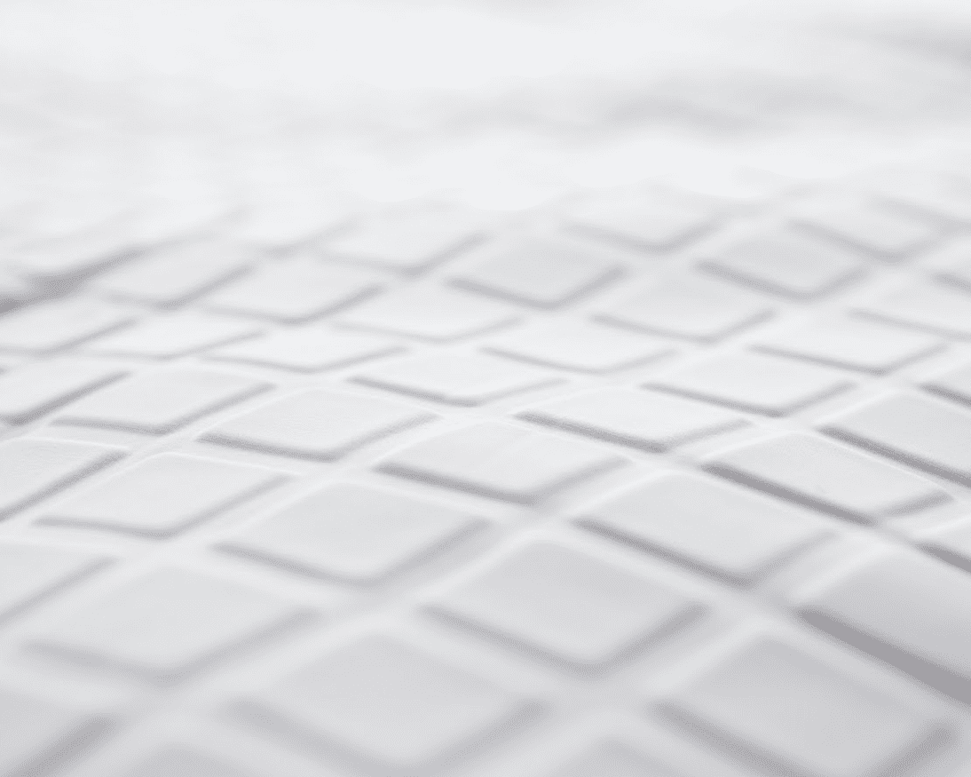 Close-up of the Opulence Glacier Blanket's white surface, featuring a repeating pattern of raised, diamond-shaped tiles that mimic its geometric, textured design. The softly focused image showcases the cooling and weighted qualities for adults.