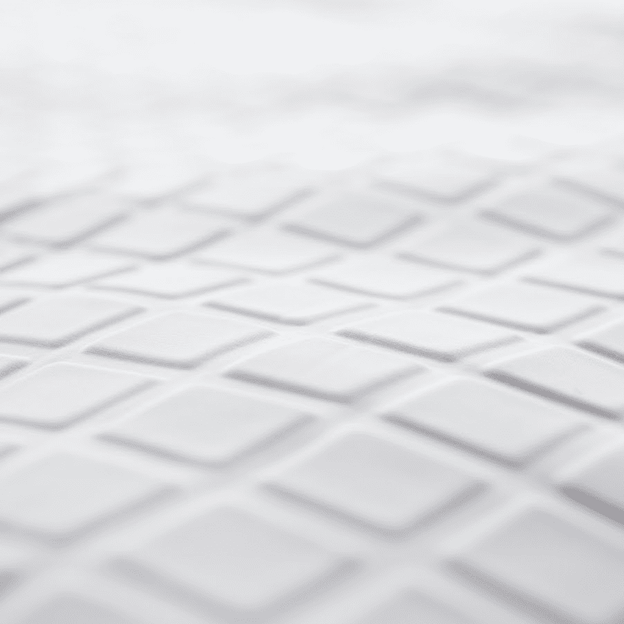 Close-up of the Opulence Glacier Blanket's white surface, featuring a repeating pattern of raised, diamond-shaped tiles that mimic its geometric, textured design. The softly focused image showcases the cooling and weighted qualities for adults.