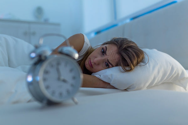 A photo of a woman having a hard time sleeping. Looking for an ergonomic pillow to help achieve better sleep? Meet the full-body pillow system that's changing everything about how we sleep.