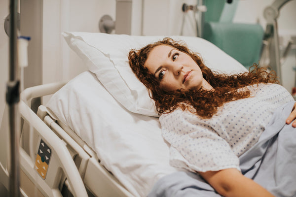 A woman lies in bed following surgery. If you're preparing for gallbladder surgery, be sure to check out our complete guide on how to sleep after gallbladder surgery and get the rest and recovery you need and deserve.