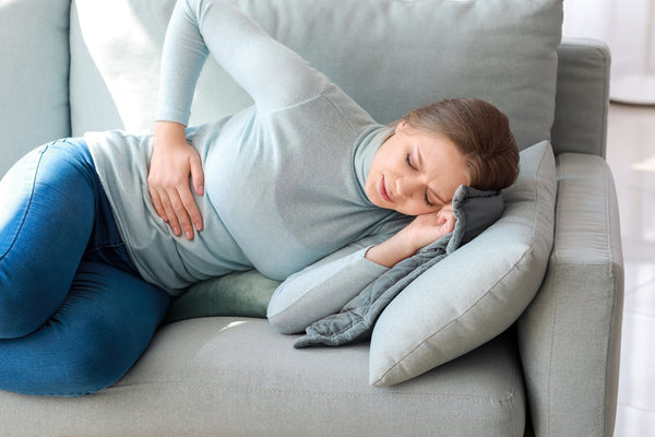 A woman with side pain. How to sleep after an appendectomy: the best positions, what to avoid, week-by-week recovery timeline, and the sleep setup worth having ready before surgery.