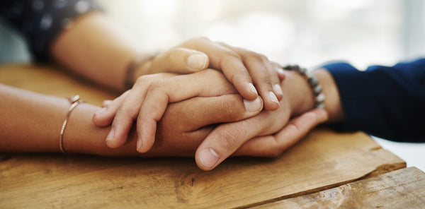 Two women hold hands. Discover thoughtful post surgery gifts for her that truly help. From positioning systems to recovery essentials, find gifts that support healing.