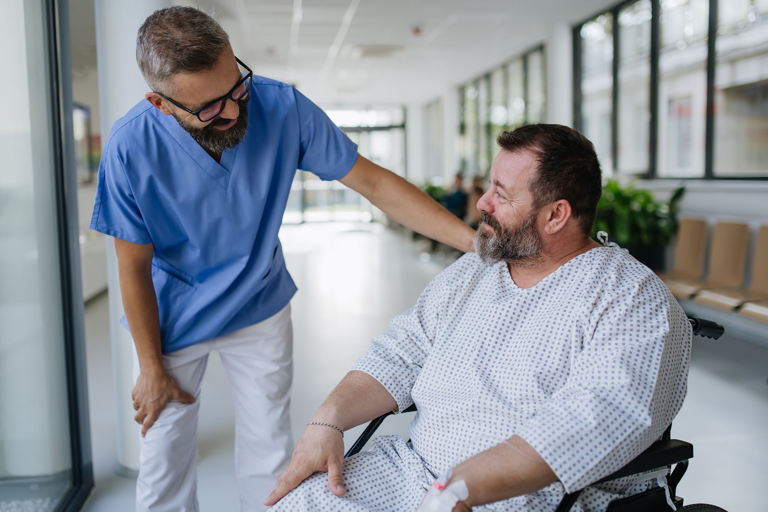 A doctor talks to a patient awaiting surgery. Learn how to sleep after gynecomastia surgery before your procedure date. Elevation angle, positioning timeline, and what to set up in advance.