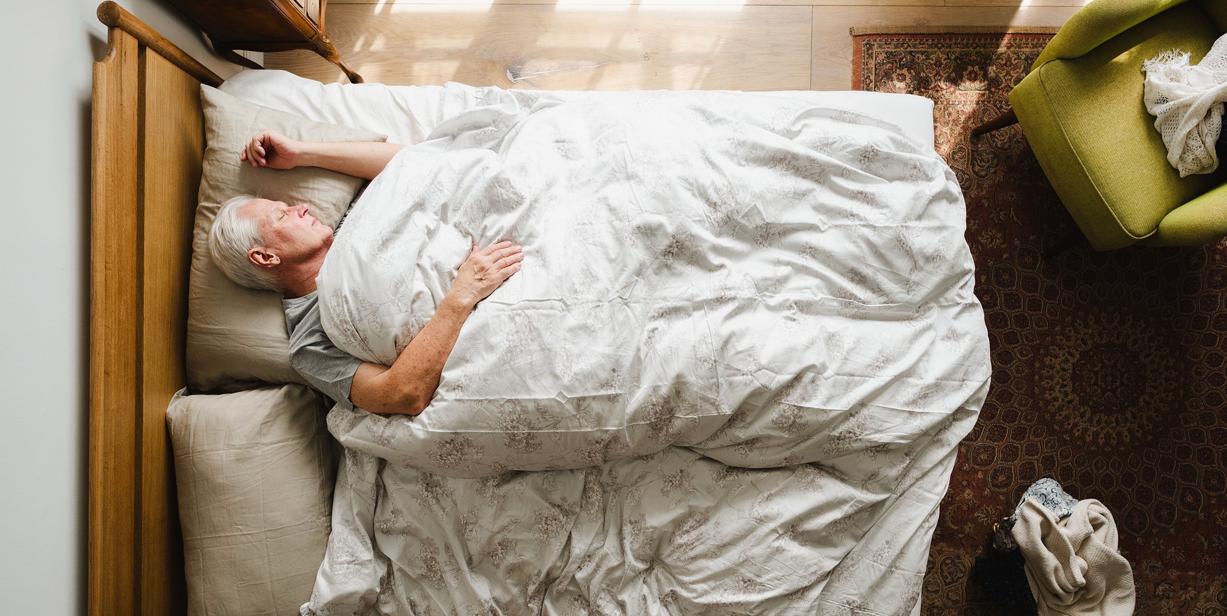 A man sleeping in bed. Sleep is when your body actually heals after surgery. Here's why it matters, what disrupts it, and how to set up your recovery sleep before surgery day itself.