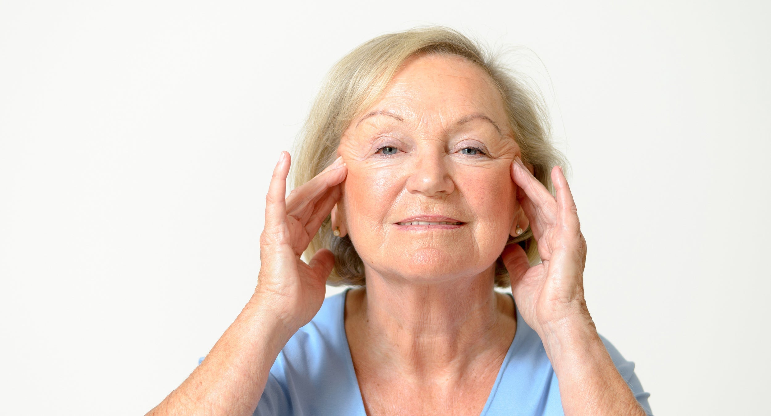 A woman looking at her own face. Planning a facelift? Explore the best facelift recovery must-haves and be prepared well before surgery day.