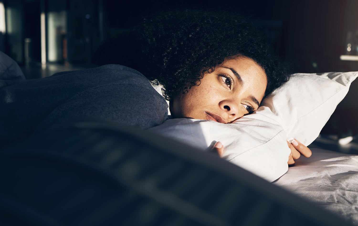 A woman struggling to sleep. Standard back sleeping isn't safe after butt implant surgery, but stomach sleeping isn't your only option. See how suspension-based positioning changes that.