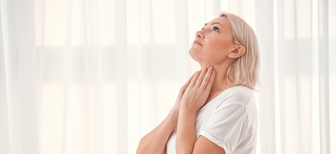 A woman touching her neck. Thyroid surgery affects how you sleep — neck positioning, swelling, and incision pain all play a role. Learn safe sleep positions for recovery.