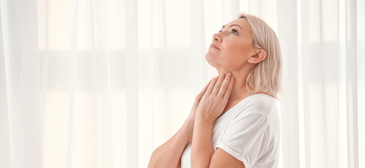 A woman touching her neck. Thyroid surgery affects how you sleep — neck positioning, swelling, and incision pain all play a role. Learn safe sleep positions for recovery.