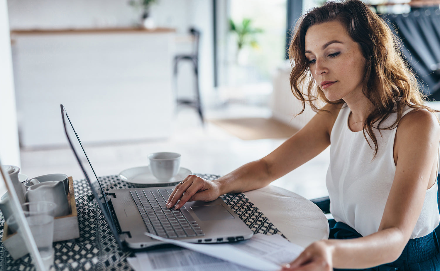 A woman creates a checklist using her computer. Looking for how to support your breast augmentation recovery? Check out our must-haves list for top healing essentials.
