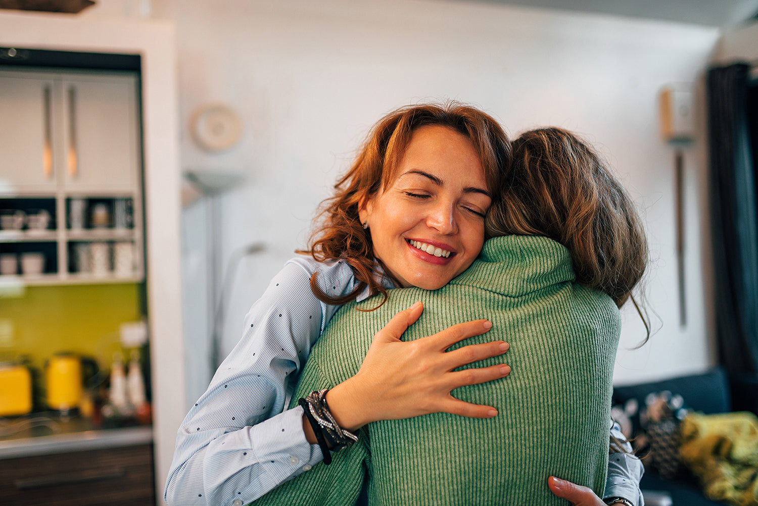 Two women hugging. Planning a gift for someone having cosmetic surgery? These 10 picks help with real recovery needs, starting with the system built for better sleep positioning.