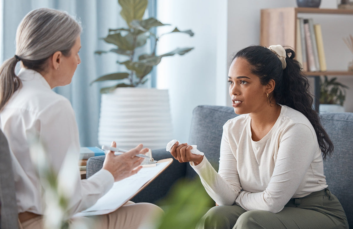 A woman talking to her doctor. A complete list of pre-mastectomy questions covering technique, reconstruction, drains, lymphedema, pain management, and recovery setup.