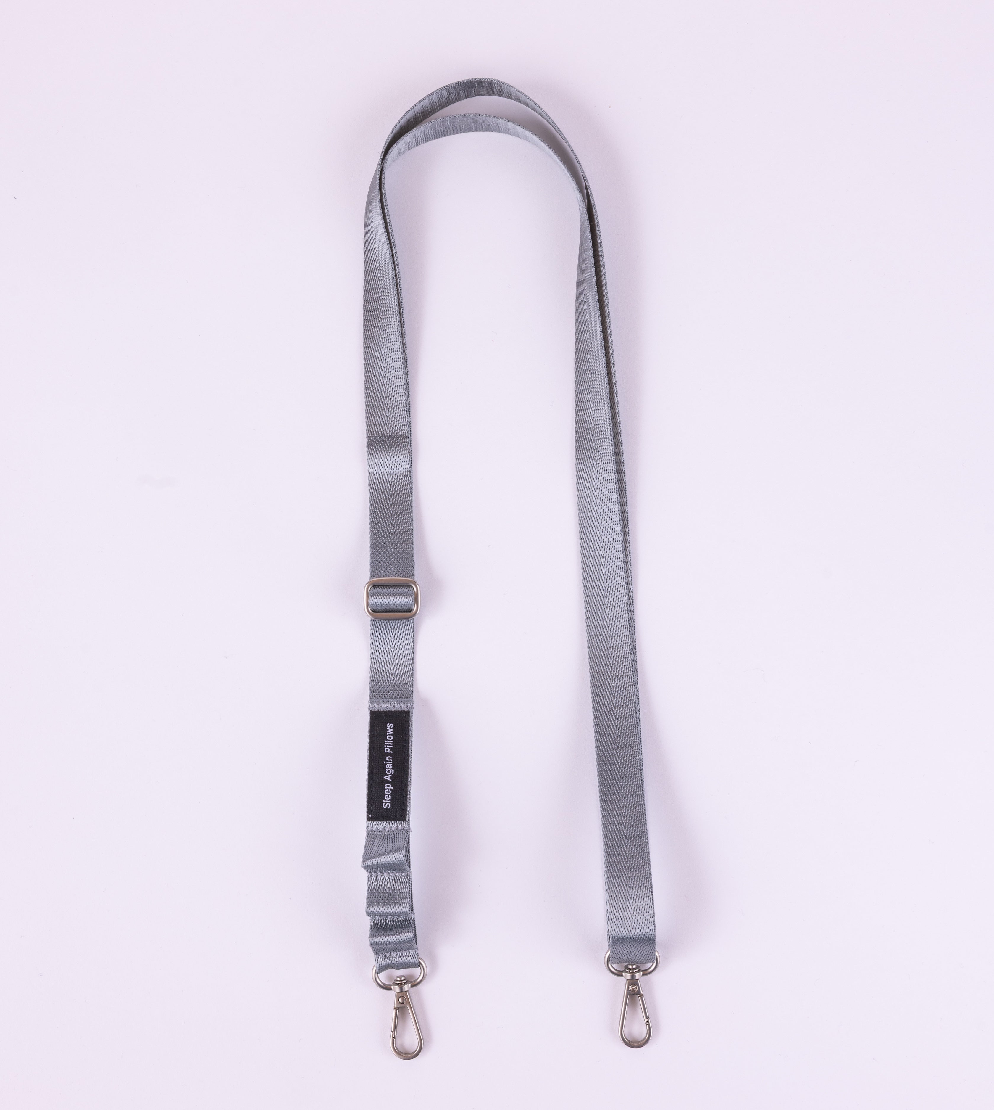 The Sleep Again Surgical Drain Holder, a light gray lanyard with metal clips at both ends for post-op drain management, is displayed in a loop on a pale background.