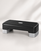 A black and gray Bedside Step Stool with a textured, non-slip surface is placed on a light background. This sturdy stool is ideal for fitness and exercise routines.