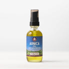 A clear glass bottle of Arnica Oil Nurture & Restore muscle massage oil with a black pump and a blue-purple label, 2 fl oz (60mL), is shown against a light background.