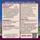 The Arnica Oil Nurture & Restore label lists pure ingredients, directions, and contact info. Its purple background features mountains, meadows, and a QR code for more on this natural skincare muscle massage oil.