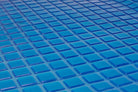 Close-up of glossy, blue square tiles arranged in a grid, evoking the soothing effect and cool tones of the Final Sale: Opulence Glacier Blanket | Cooling & Weighted for adults.