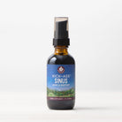 A brown bottle with a black spray cap labeled Kick-Ass Sinus, Move & Soothe sits on a white surface—a natural herbal choice for sinus and upper respiratory support.